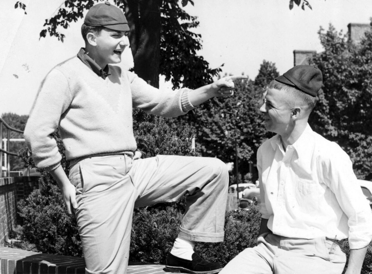 Black and white photo from 1906 with two male students wearing tiny baseball caps called "dinks" to show that they are underclassmen